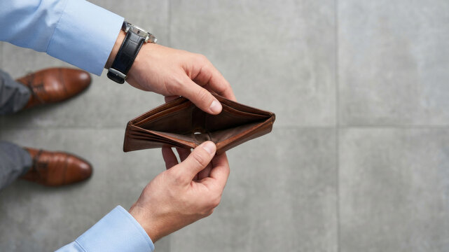 Empty wallet crisis finance debt poverty stress budget worry man hand leather gray tile top view. Financial bankruptcy recession. open purse broke, debt problem loss, money cash spending pay, poor