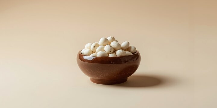 Brown bowl filled with white soap nut shells for medicine on a plain setting