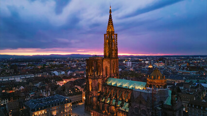 Fototapeta premium Strasbourg cathedral spire illuminating strasbourg city at twilight