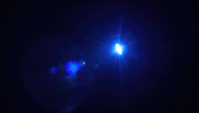 Blue Flashlight Emitting Sharp Ray Streaks Dark Background, Glowing Lens Flare