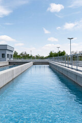 Fototapeta premium Modern Water Treatment Plant with Clear Blue Water under Bright Sky Day