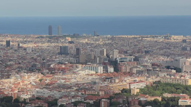 Expansive barcelona cityscape showing dense urban development and the mediterranean sea from an aerial viewpoint, highlighting the iconic skyline on a sunny day in spain