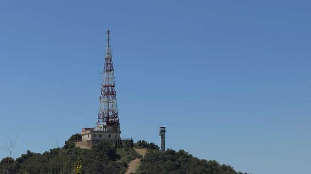 Telecommunications tower transmitting radio and tv waves against a clear blue sky, a crucial infrastructure for wireless broadcasting, communication and technology