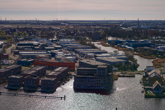 Wormerveer, Netherlands - 15 May 2026: Aerial view of the former De Pijl factory awaiting redevelopment, surrounded by modern residential islands and industrial buildings.