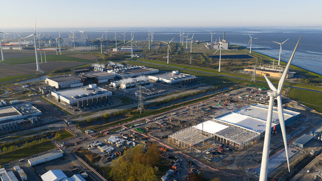 Eemshaven, Netherlands - 21 April 2026: Aerial view of the Google GRQ data center construction site surrounded by wind turbines and industrial infrastructure near the coast.