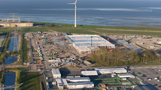 Eemshaven, Netherlands - 21 April 2026: Aerial view of the Google GRQ data center construction site surrounded by wind turbines and industrial infrastructure near the coast.