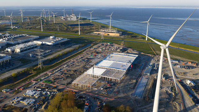Eemshaven, Netherlands - 21 April 2026: Aerial view of the Google GRQ data center construction site surrounded by wind turbines and industrial infrastructure near the coast.