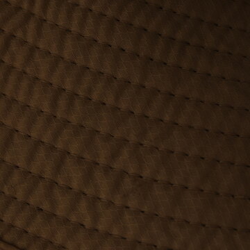 Dark brown quilted leather texture close-up background pattern