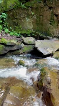 Mountain Stream Flowing Over Ancient Rocks in Vertical Format