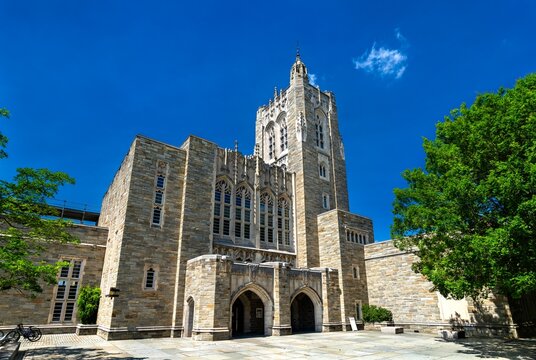 Princeton, New Jersey - July 4, 2025: Gothic-style Princeton University Library featuring stone masonry, pointed arches, and a central tower surrounded by lush greenery.