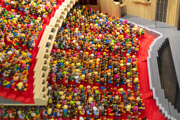 Obraz premium Many Lego figures are seated in a theater, watching a show. The arrangement creates a lively scene, showing a mix of colors and designs among the figures