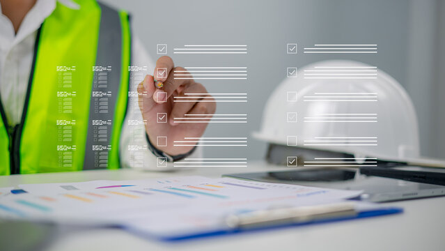 Professional male engineer in safety vest using digital checklist interface for construction quality control, site inspection, and safety management report on virtual screen office background.