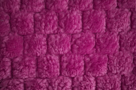 Magenta pink fluffy knitted fabric texture background, fuchsia chenille textile pattern closeup