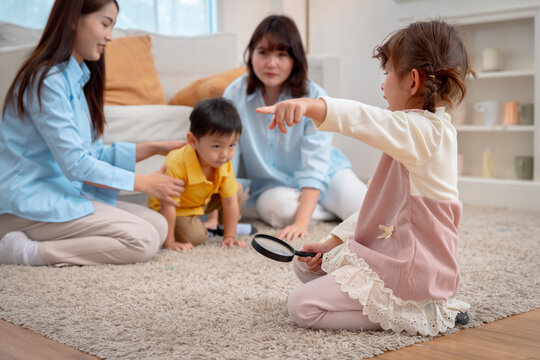 Curious children with magnifying glass and supportive parents