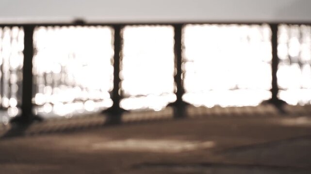 A coastal deck fence with a reflective ocean surface in the background