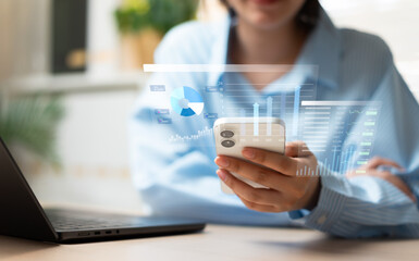 Businesswoman using smartphone for investment and mobile banking, managing money, budget, and financial funds through digital technology and smart business planning. © Father_Studio