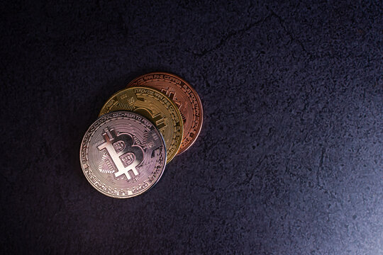 Stacked bitcoin coins with metallic reflections on granite surface