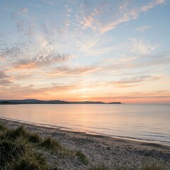Obraz premium Serene Coastal Sunset with Calm Ocean and Sandy Beach at Golden Hour