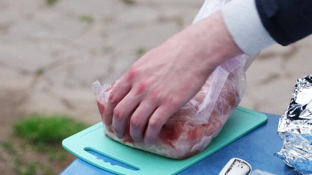 Preparing meat for grilling on a sunny day in the backyard