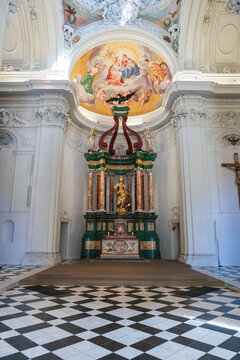 Luxurious interior of the Mausoleum of Emperor Ferdinand II in Graz featuring ornate marble altar, fresco paintings, and black and white checkerboard floor