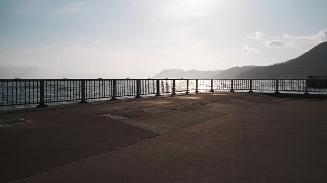 A coastal deck fence with a reflective ocean surface in the background
