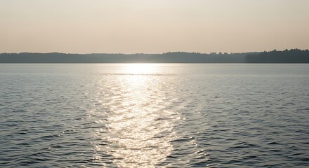 Obraz premium Golden sunset light reflecting on a calm lake surface at twilight