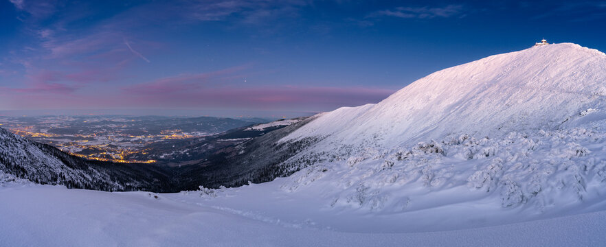 evening landscape of Karkonosze mountains with Snezka and illuminated jeleniogorska valley during winter 