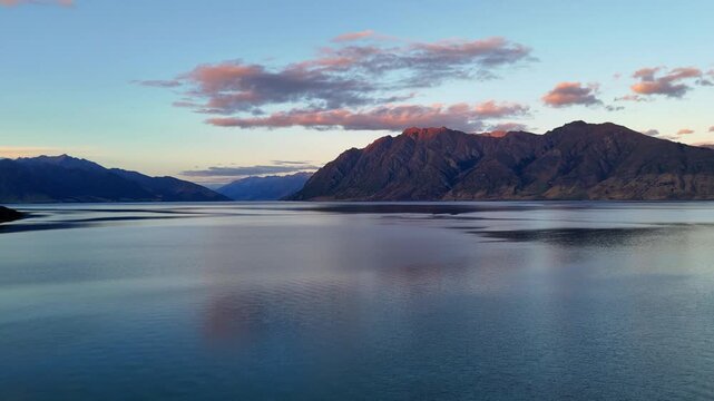 Aerial drone view of a stunning sunset over the New Zealand countryside. Scenic rural landscape with golden light.