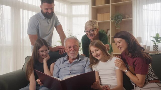 Happy family gathering with grandfather showing old photos in cozy home atmosphere