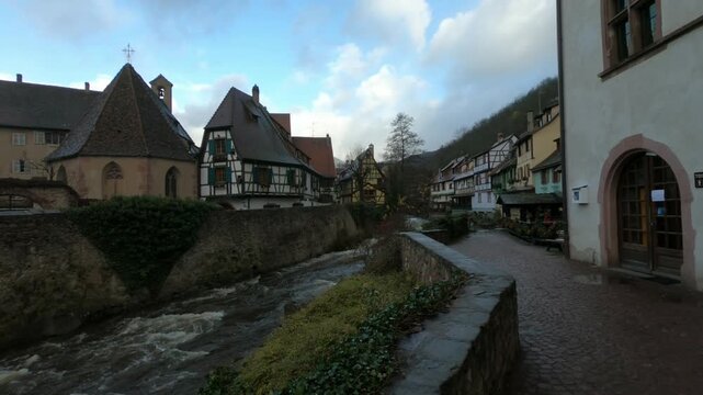 The Weiss river running between half timbered houses, Kaysersberg, Alsace, France, Europe. River with strong current flowing through the rocks.