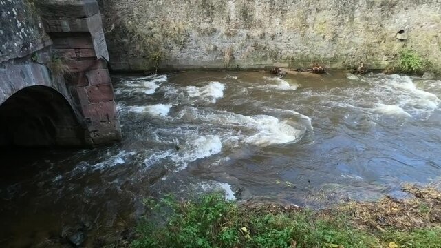 The Weiss river running between half timbered houses, Kaysersberg, Alsace, France, Europe. River with strong current flowing through the rocks.