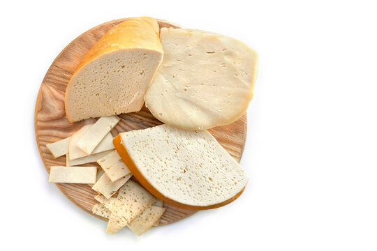 Traditional Smoked Hutsul craft cheese budz with slices on round wooden board, top view
