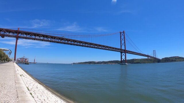 Christ-King and the 25 April Bridge (Ponte 25 de Abril), a steel suspension bridge located in Lisbon, Portugal, crossing the Tagus River (Rio Tejo).