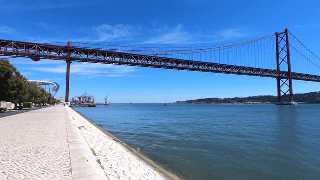 Christ-King and the 25 April Bridge (Ponte 25 de Abril), a steel suspension bridge located in Lisbon, Portugal, crossing the Tagus River (Rio Tejo).