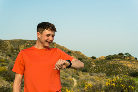 Man tracking fitness progress on smartwatch during outdoor running