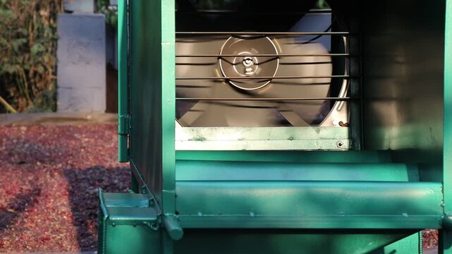 Industrial exhaust fan operating on coffee cherry cleaning machine during the processing. Direct drive blower fan working