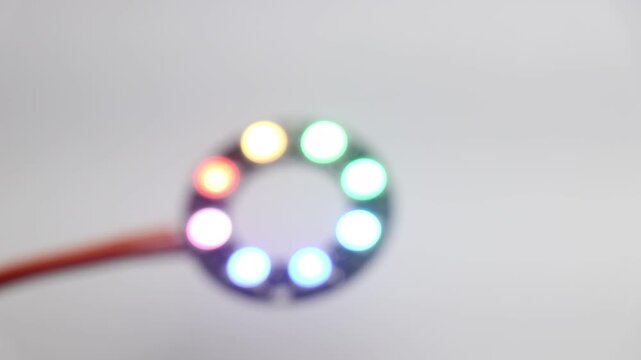 RGB LED ring light glowing colors of different shades and patterns on a blurred background. Testing electronic components