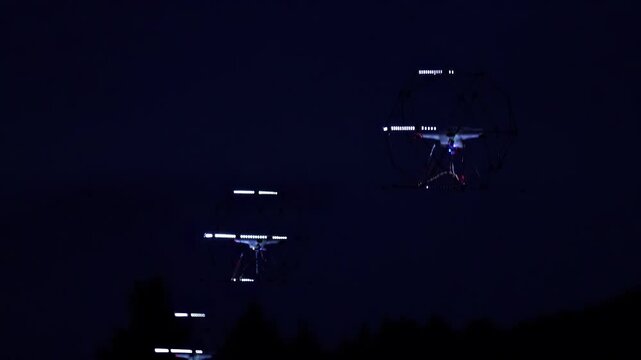 Nighttime drone swarm with illuminated structures and aerial performance