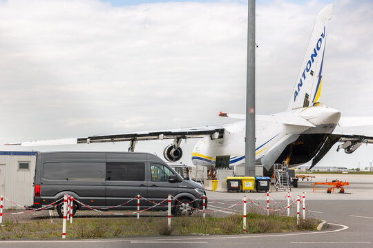 Schkeuditz, Germany - 9 May, 2026. Antonov an 124 cargo aircraft undergoing maintenance on airport apron with opened loading section and service equipment nearby.