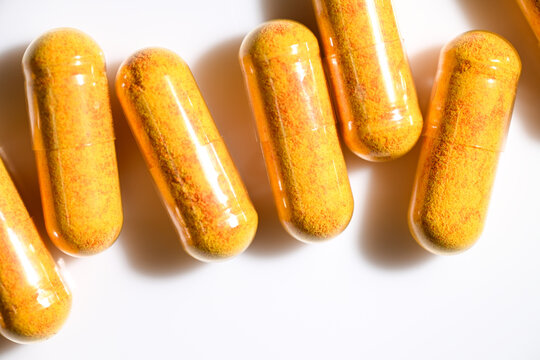 Close up of Orange Capsule Pills with Curcumin Turmeric Supplement Inside