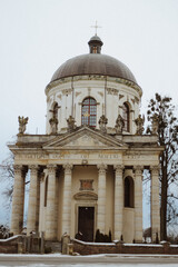Obraz premium The Church of St. Joseph in Pidhirtsi, Ukraine, is a Roman Catholic Baroque rotunda built between 1752 and 1766, featuring a fourteen column portico and limestone saint statues architecture landmark.