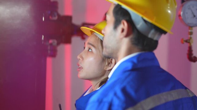 Chinese female hardware specialist holding a digital tablet to demonstrate a semiconductor RAM bandwidth efficiency dashboard to her Indian manager.
