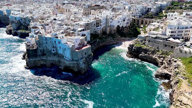 Polignano a Mare with Lama Monachile beach. Aerial 4K drone video footage with panorama view of stunning coastal townscape in Puglia, southern Italy