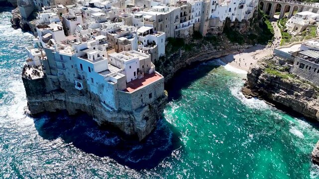 Polignano a Mare with Lama Monachile beach. Aerial 4K drone video footage with panorama view of stunning coastal townscape in Puglia, southern Italy