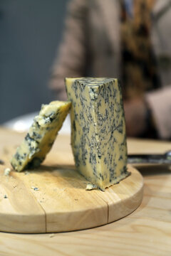 cu&ntilde;as de queso azul artesanal en una tabla de madera
