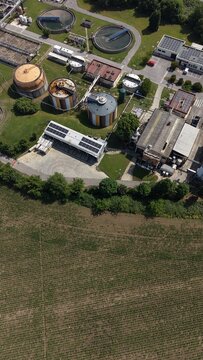 Aerial View of Industrial Facility: An overhead shot captures a complex industrial plant, complete with large storage tanks, processing units, and solar panels.