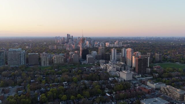 Golden hour illuminating Toronto's midtown skyline, featuring Yonge and Eglinton residential and business buildings with prominent skyscraper under construction