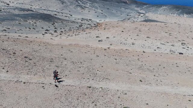 Aerial View of Hikers Trekking Across the Arid Desert Dunes of the Isthmus of La Pared, Fuerteventura