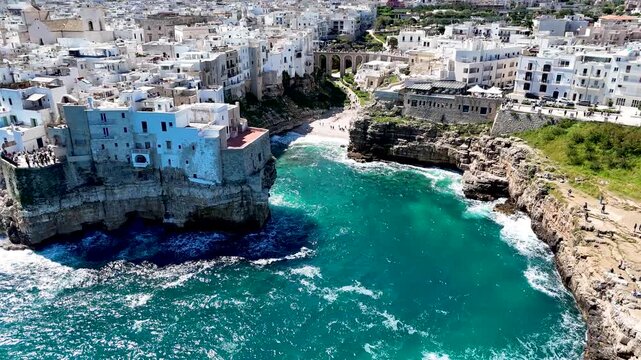 Polignano a Mare with Lama Monachile beach. Aerial 4K drone video footage with panorama view of stunning coastal townscape in Puglia, southern Italy