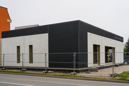 Modern minimalist residential building exterior under construction with black and white facade design